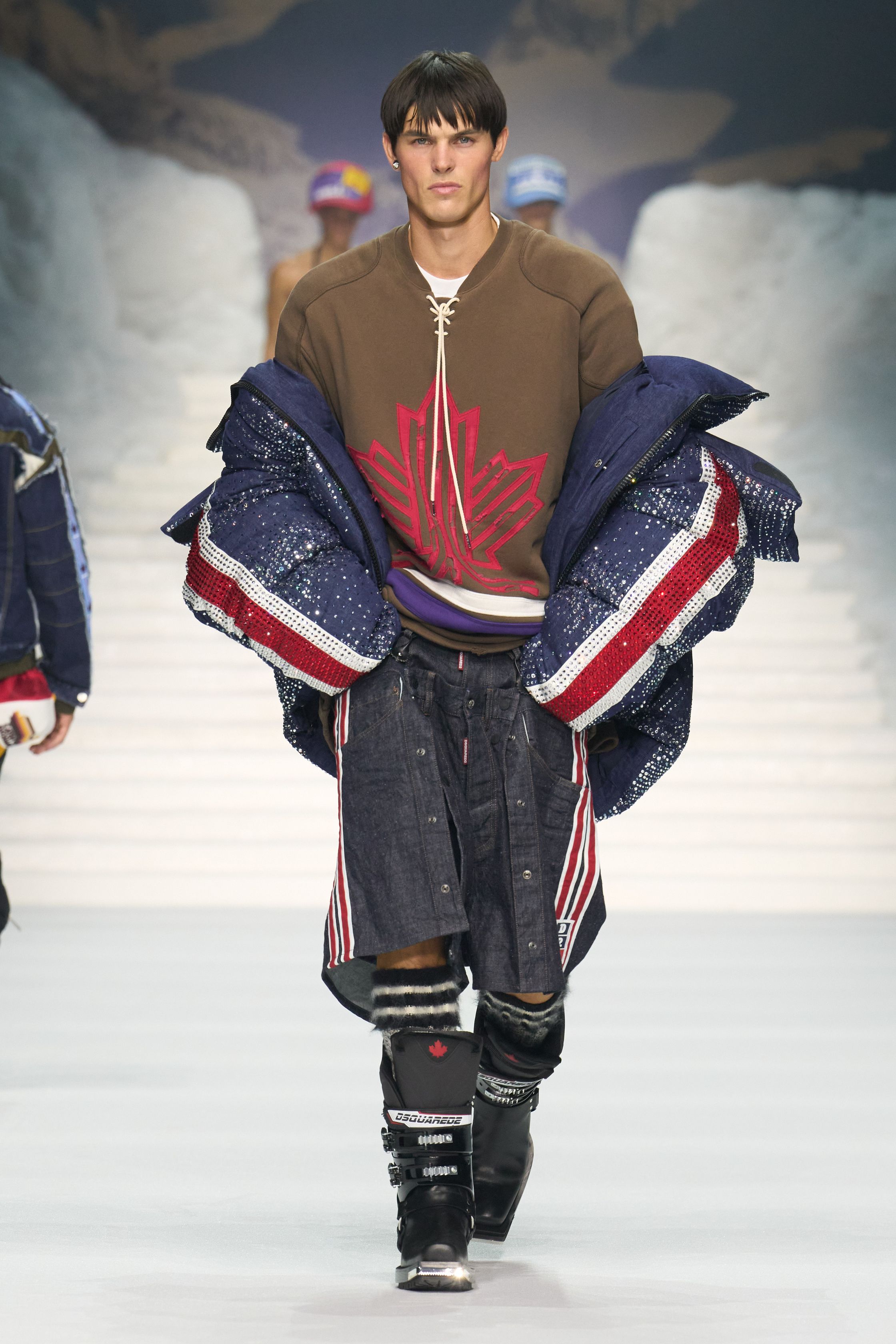 Dsquared2 2026秋冬以夸张的滑雪场景为背景，将加拿大户外精神、Y2K 性感与舞台化时装推至极致。羽绒、毛皮、紧身牛仔与夸张比例不断叠加，身体成为视觉焦点，性感、力量与炫耀被无限放大。这不是现实主义的衣橱，而是一场关于冒险、欲望与表演的时尚狂欢，张扬而直接，忠于品牌一贯的高能量叙事-顽石频道趋势研究